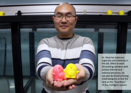 Dixia Fan, PhD, holding two 3D printed penguins, the Guardians of the Intelligent Towing Tank, which he is standing in front of