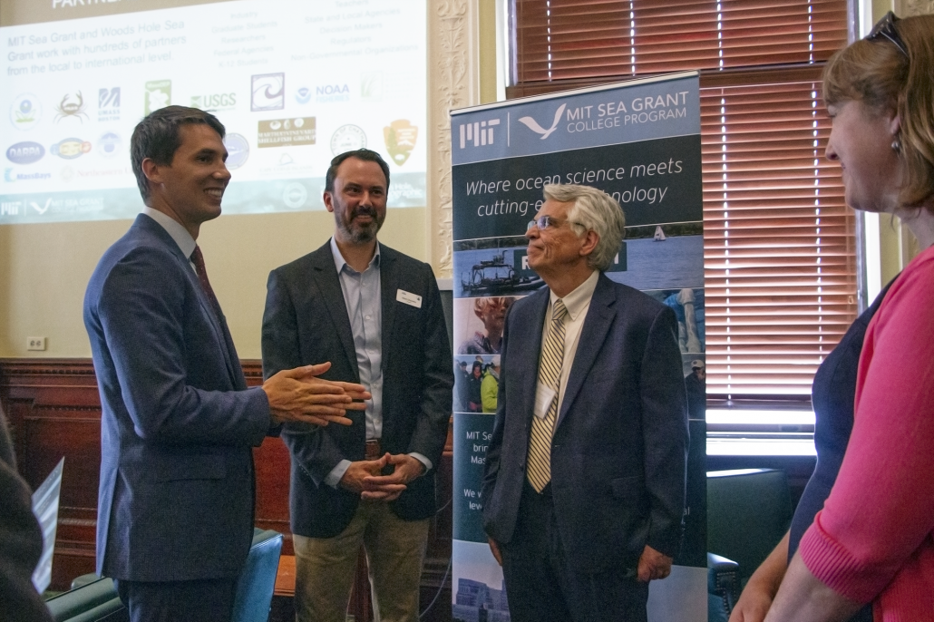 Rep. Dylan Fernandes, Matthew Charette and Michael Triantafyllou talk after a presentation on the Blue Economy at the State House