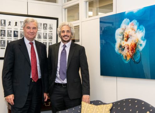 Senator Whitehouse meets and Keith Ellenbogen stand next to a large image of a jellyfish floating in blue water.