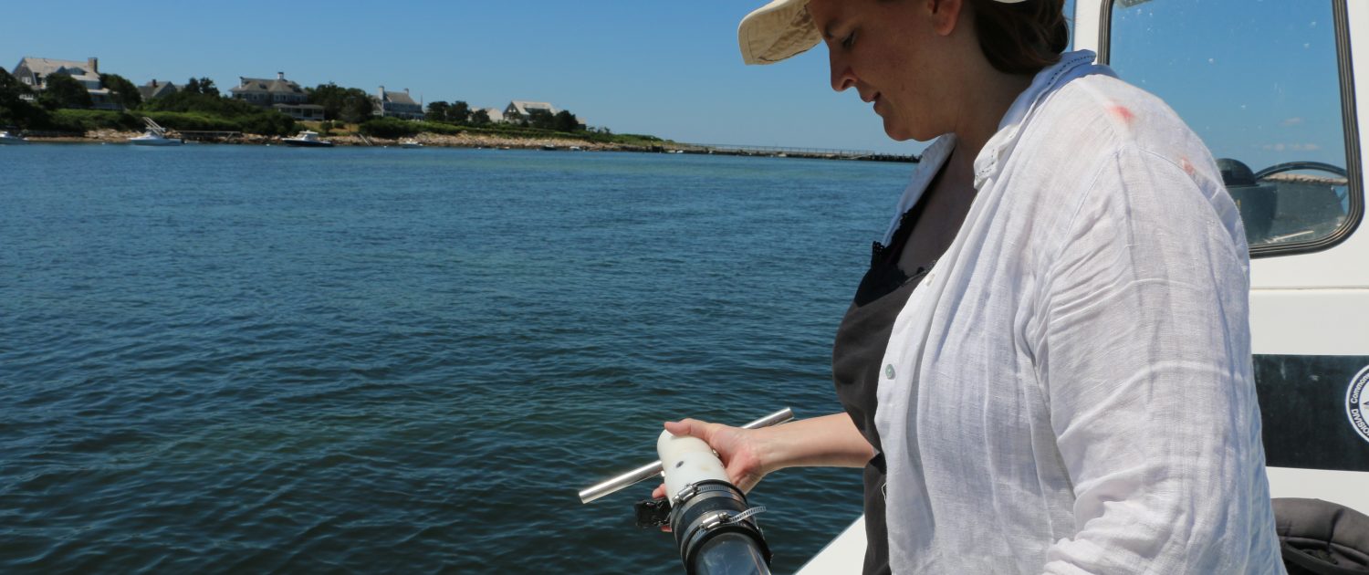 Dr. Juliet Simpson holds sediment core on a boat in Massachusetts.