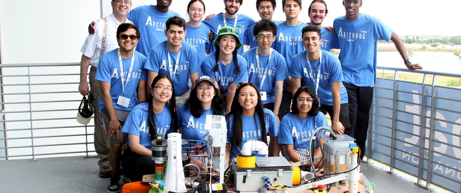 MIT Arcturus Team with MIT Sea Grant Education Administrator Drew Bennett and their autonomous vessel at the 2023 RoboBoat Competition