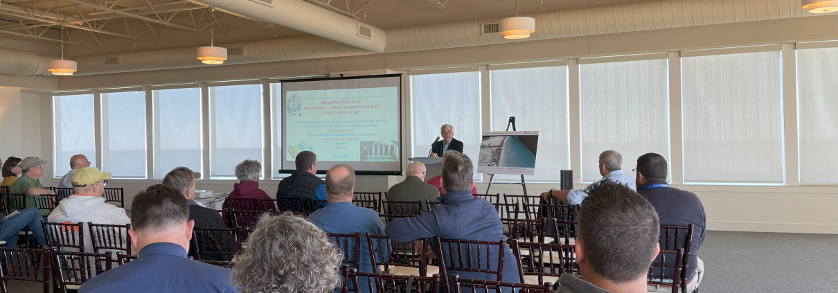 MIT Sea Grant Director Michael Triantafyllou speaking to a room of people.