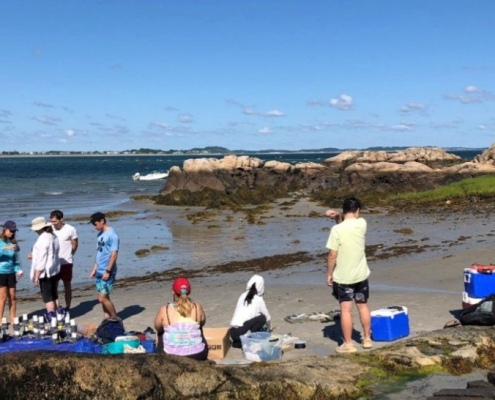 Field crew on a beach assembling equipment and waiting for divers to return with sediment cores. Photo credit: Heidi Nepf